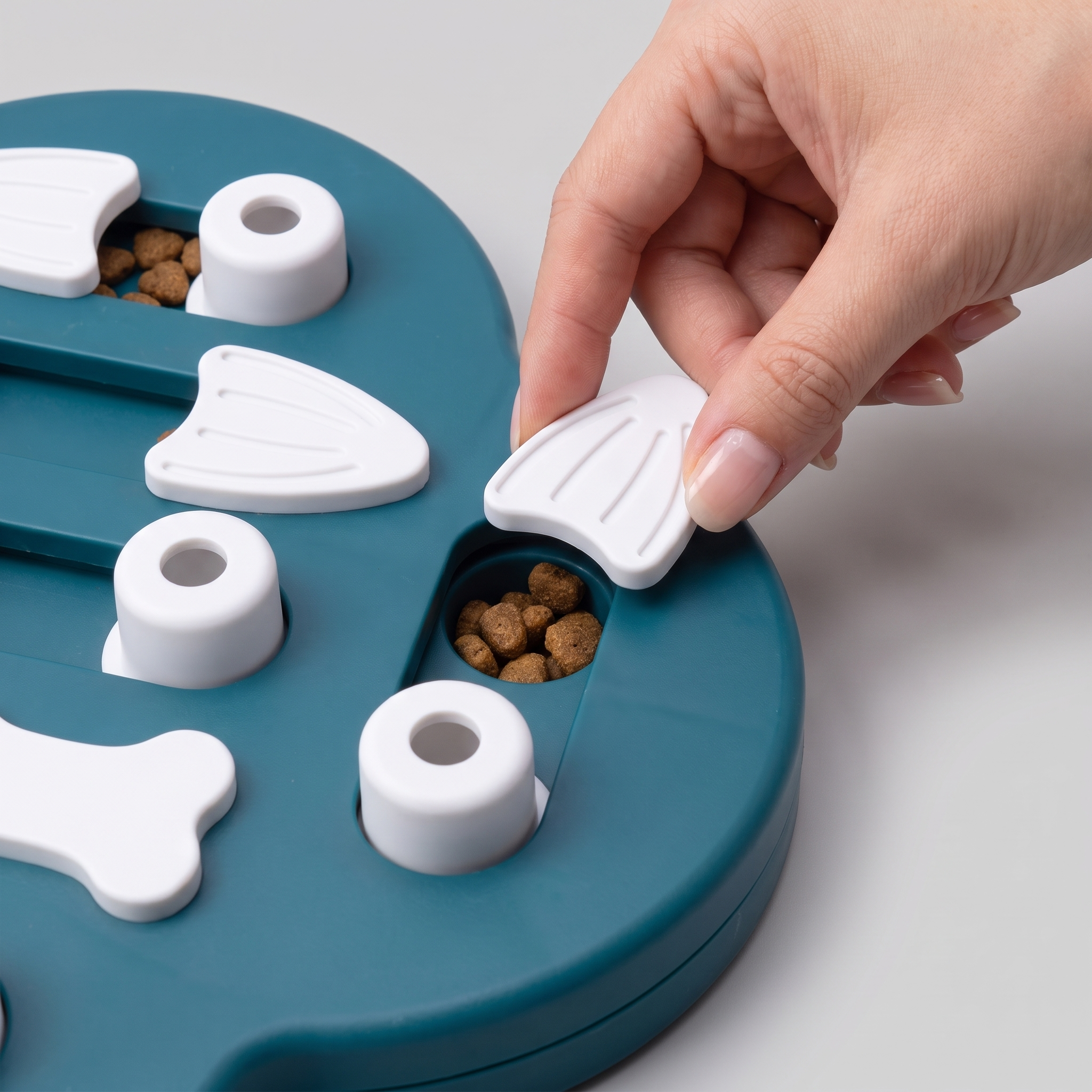 Sliding open a panel on the Slide & Seek puzzle to reveal a treat well
