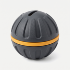 Click & Treat Training Reward Ball in matte charcoal grey and marigold-orange on a light neutral background