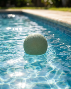 Splash Flex Bounce Ball floating on a sunlit swimming pool